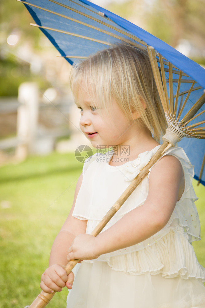 可爱的女婴在外面公园里拿着阳伞图片