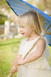 可爱的女婴在外面公园里拿着阳伞图片