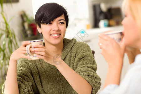 多族裔有吸引力的年轻女子在厨房里与朋友交往图片