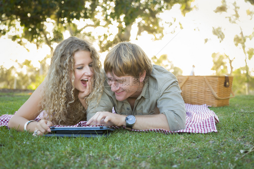 情侣趴在草地上用电脑图片