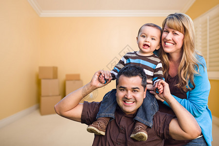 快乐的年轻人混合种族家庭与搬箱的房间图片