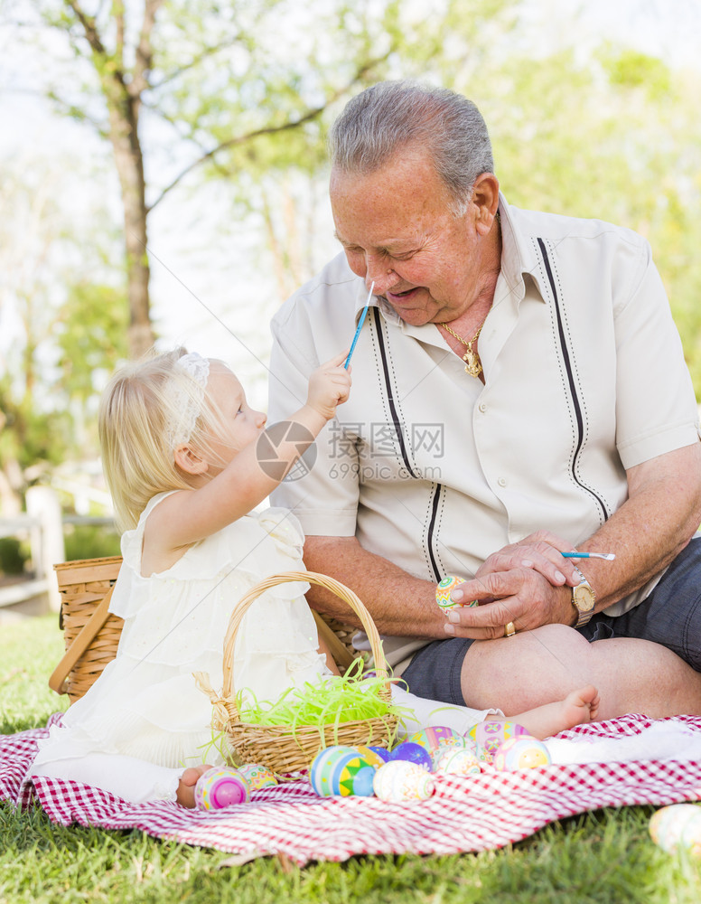 祖孙两人在野餐垫子上给蛋壳绘画图片