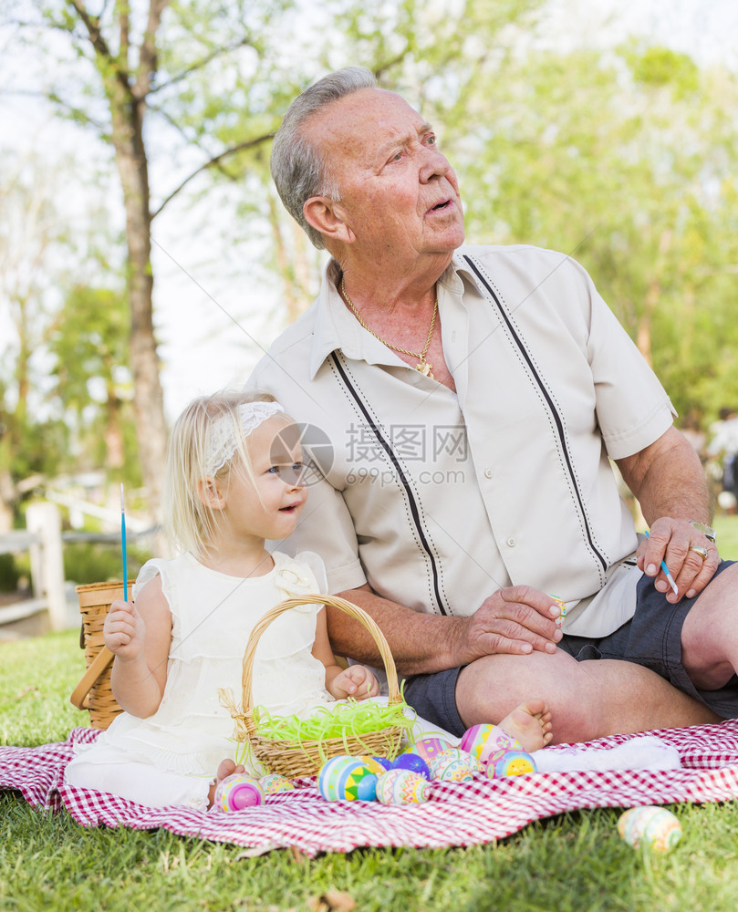 祖孙两人在野餐垫子上向远方望去图片