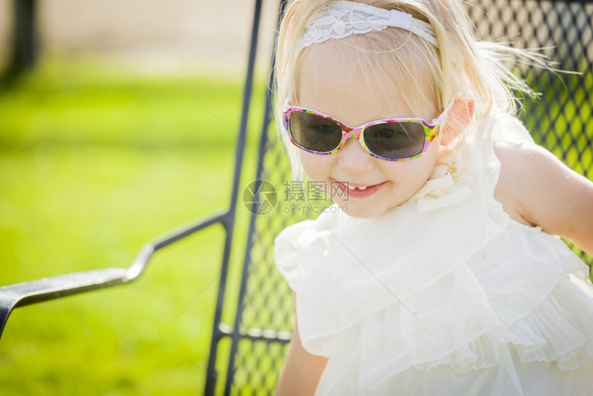 可爱的嬉皮女婴穿着太阳镜在公园外面图片