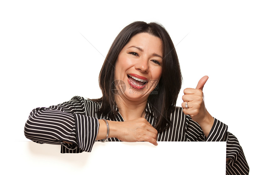 有魅力的多族裔微笑着妇女仰靠空白标志手拇指在白背景上被孤立图片