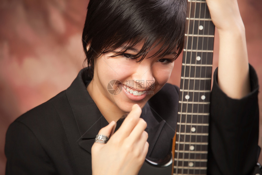 多族裔女孩用她的电吉他摆姿势图片