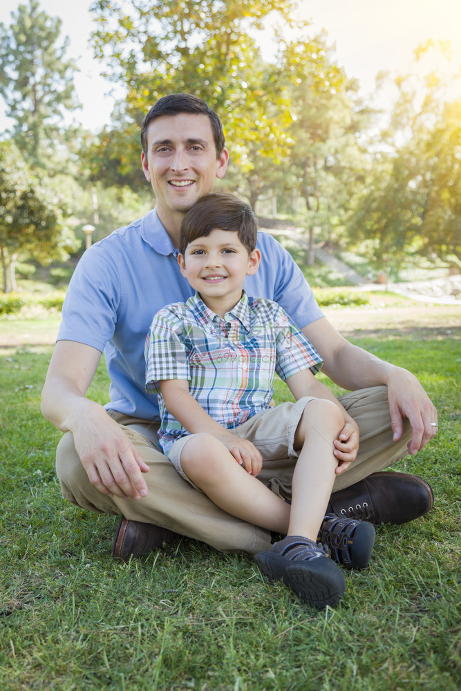 英俊的混合种族父亲和年轻的儿子肖像在公园里图片