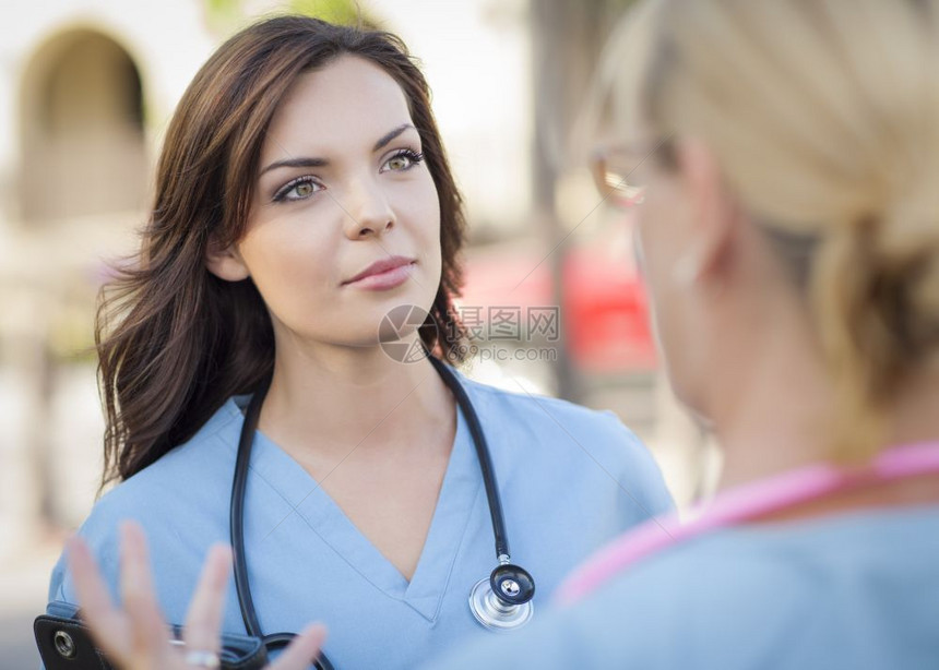 两名年轻的成专业女医生或护士在外面交谈图片