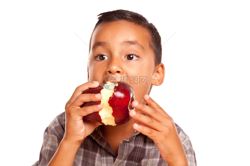 可爱的西班牙男孩吃一个大红苹果孤立在白色背景图片