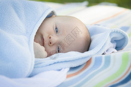 美丽的小男孩在他温暖毯子休息图片