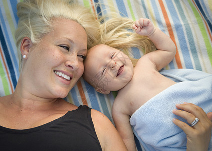 婴儿依偎在妈妈怀抱里开心的笑起来图片