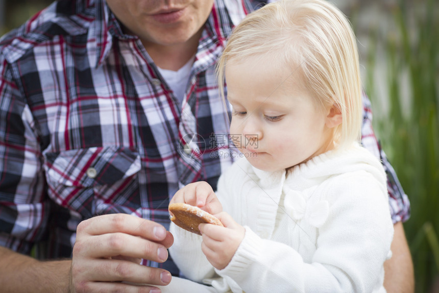 可爱的小女孩吃饼干和爸在外面图片