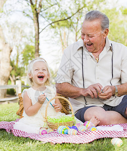 祖孙两人在野餐垫子上大笑背景图片