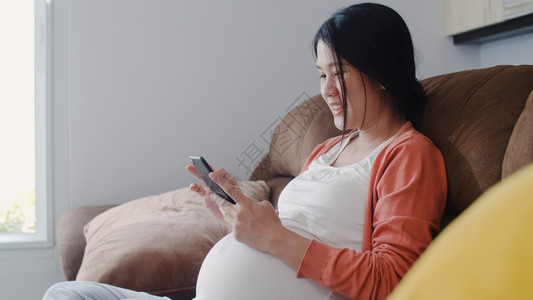 孕妇坐在沙发上看手机图片