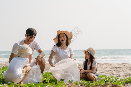 在海滩上收集塑料垃圾的快乐家庭图片