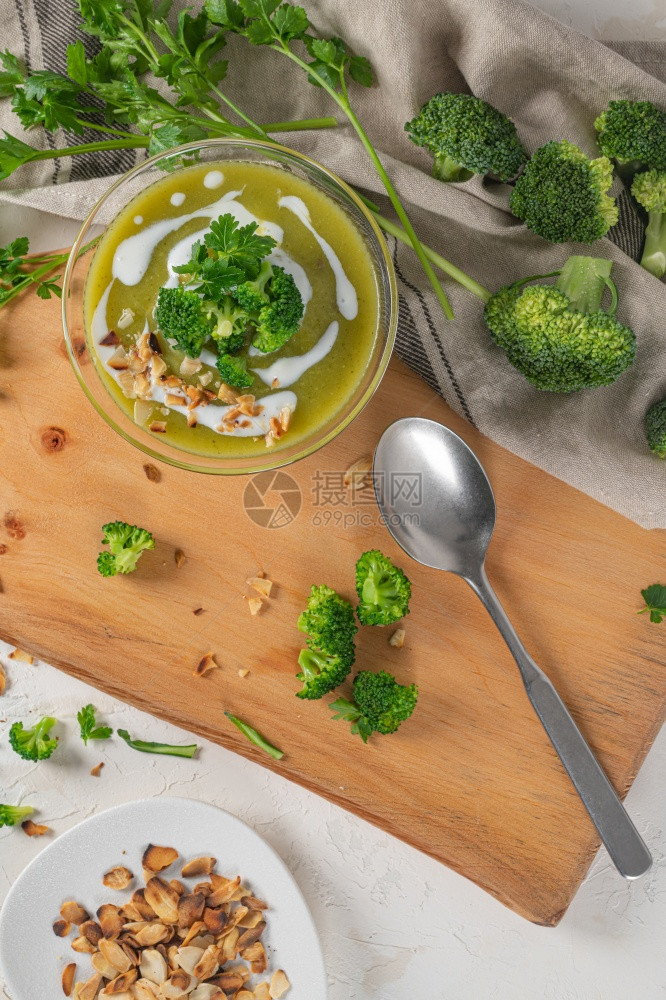 准备吃新鲜热辣的西兰花纯汤配有椰菜和鹦鹉叶放在木制桌上的碗里关闭健康饮食和生活方式顶层视图图片