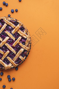 土制蓝莓馅饼夹着花边壳平铺上美味的蓝莓甜点水果蛋糕在风上方图片