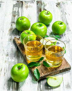 苹果汁在木板上的玻璃杯里在白色木板背景上苹果汁在木板上的玻璃杯里图片