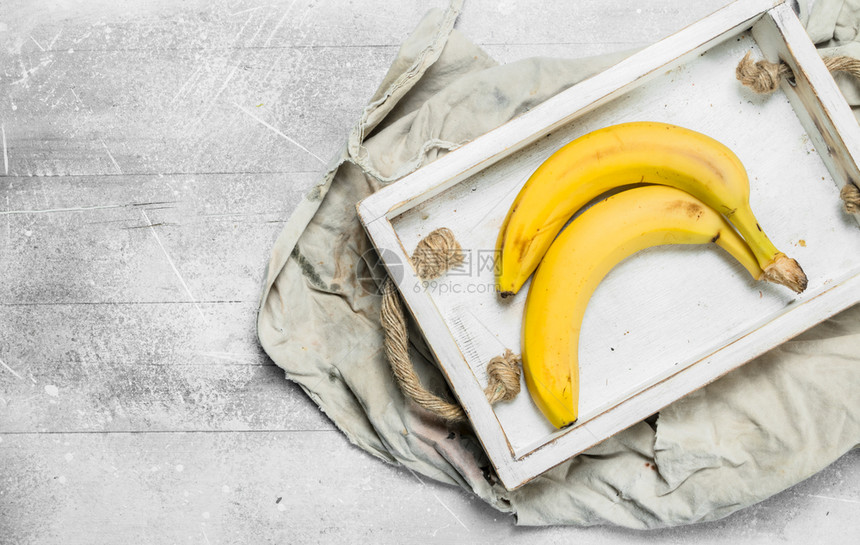 新鲜香蕉在木箱里白色生锈背景图片