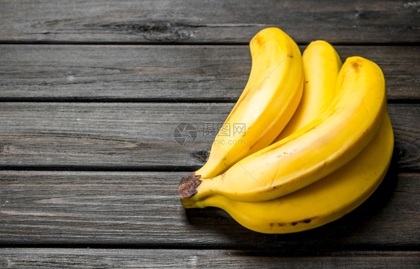 新鲜黄香蕉黑木本底图片
