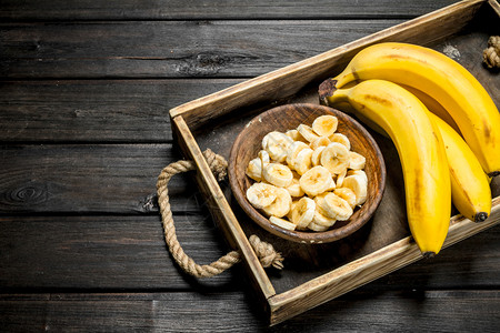 香蕉和一块板子上面有香蕉片放在木质布料上香蕉和一块板子放在木质布料上图片