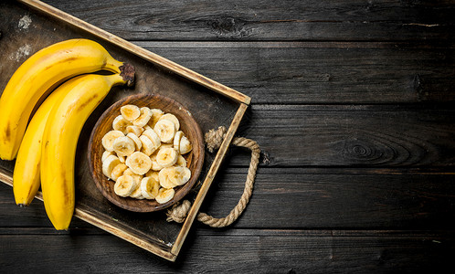 香蕉和一块板子上面有香蕉片放在木质布料上香蕉和一块板子放在木质布料上图片