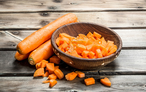 碗上的胡萝卜木质背景的胡萝卜背景图片