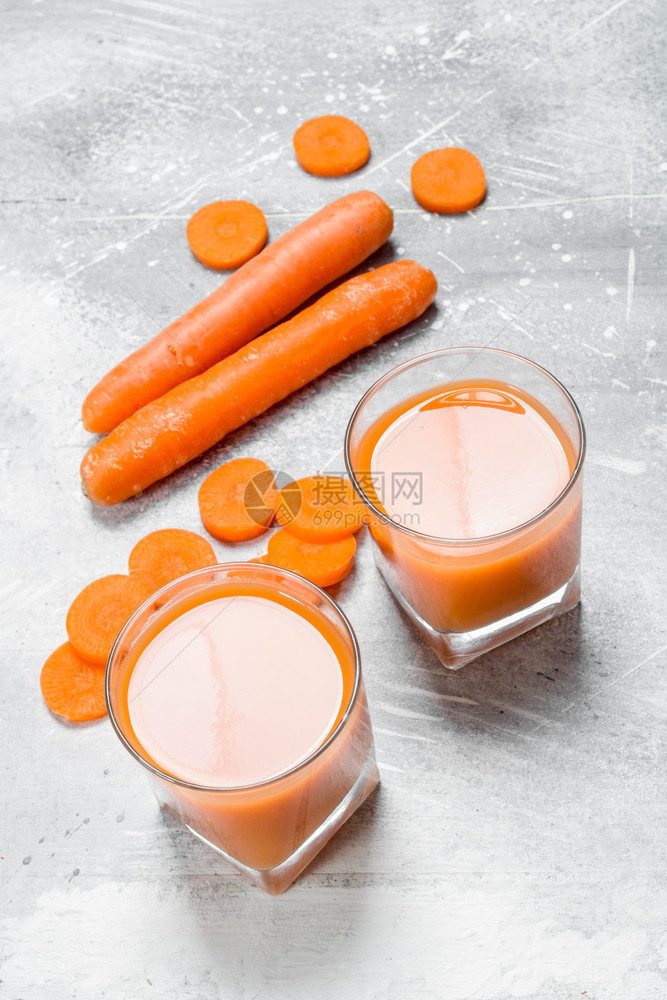 杯子里的胡萝卜汁生锈背景的胡萝卜汁图片
