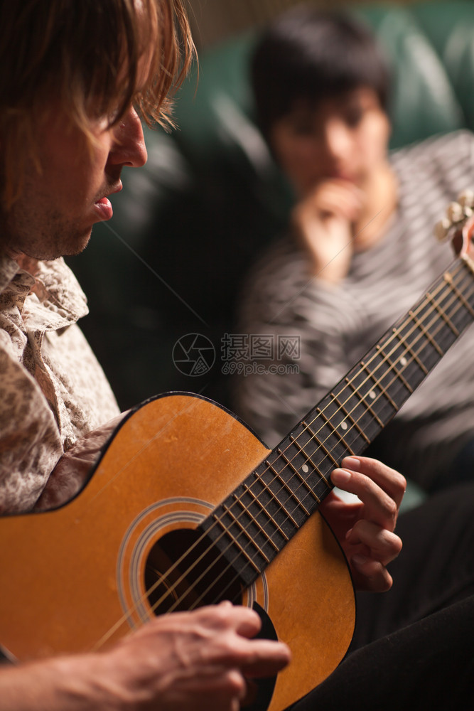 年轻音乐家作为背景听众的朋友弹奏他音响吉图片