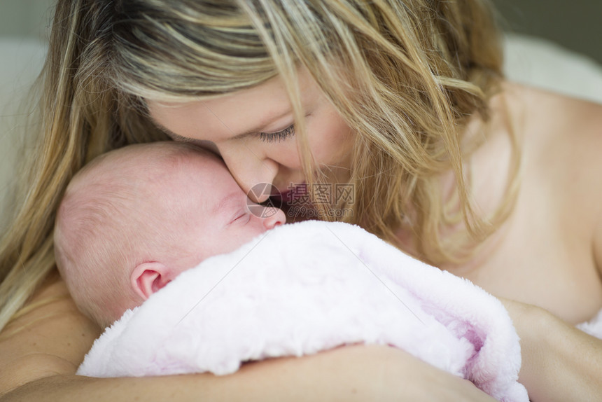 美丽的母亲抱着她珍贵的新生女婴图片
