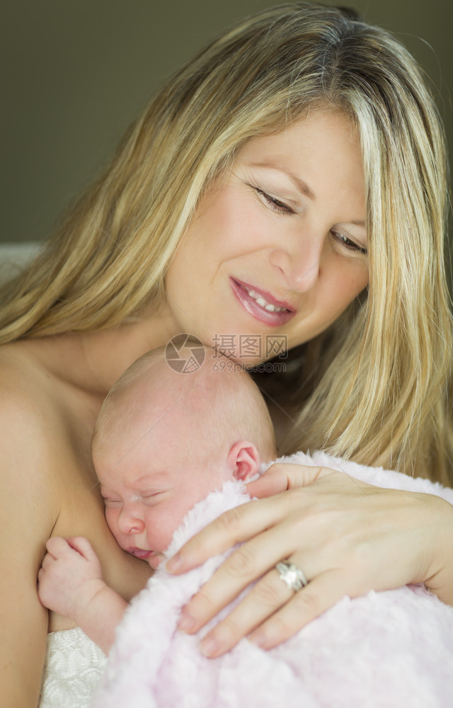 年轻的天主教青美丽的母亲抱着她珍贵的新生女婴图片