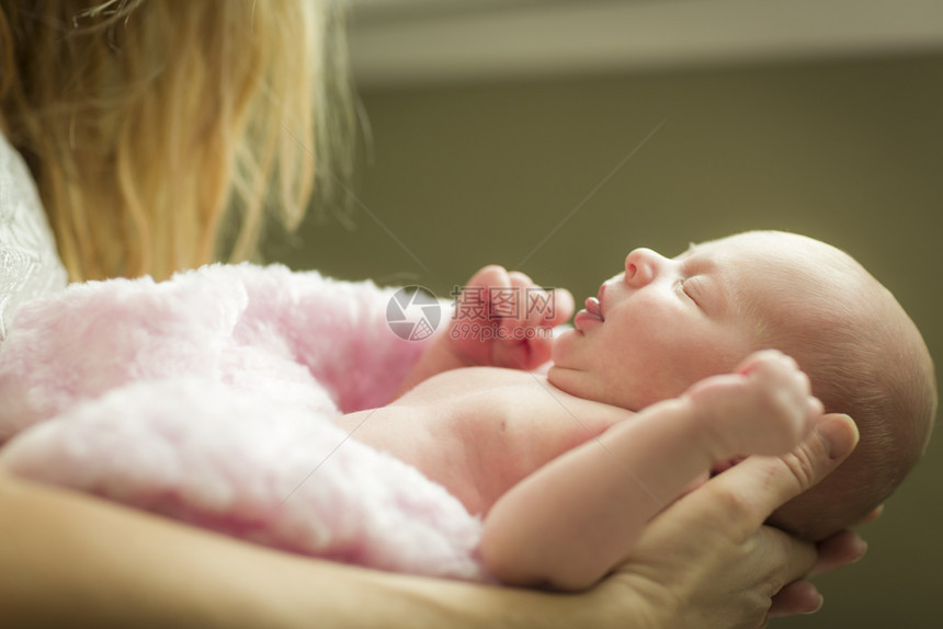 母亲温柔的手抱着她珍贵的新生女婴图片