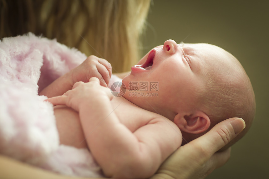 母亲温柔的手抱着她珍贵的新生女婴图片