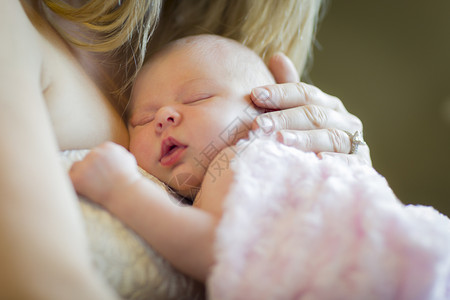 母亲温柔的手抱着她珍贵的新生女婴背景图片