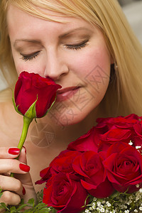 女人闻着一束红玫瑰的味道图片