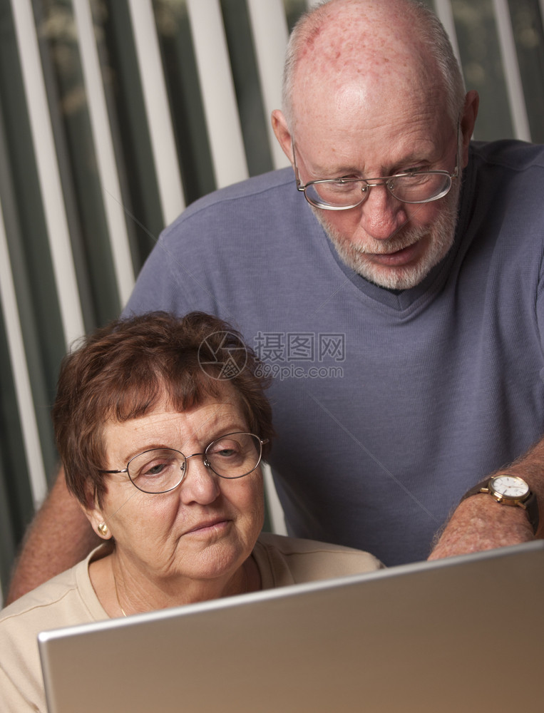 在电脑笔记本上玩得开心的老年夫妇图片