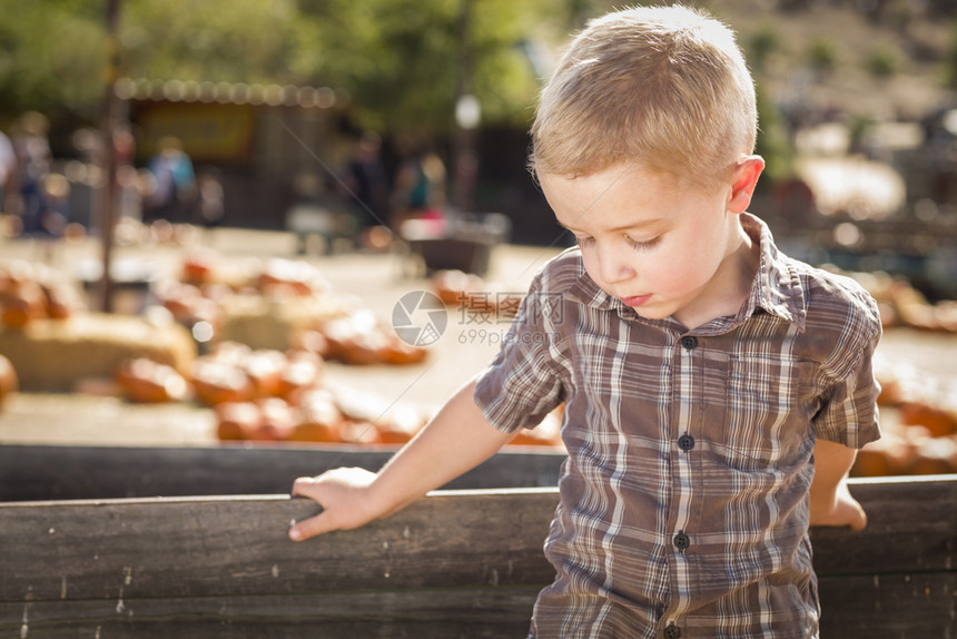 小男孩站在旧马车旁边图片