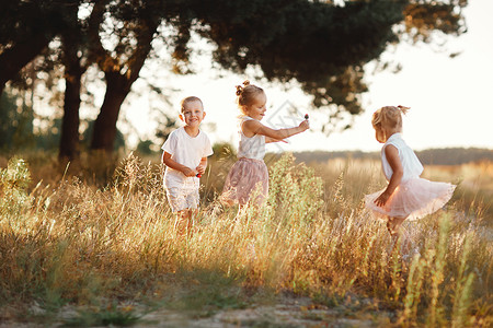 夏季有3名儿童在田野玩耍时无忧虑的微笑图片