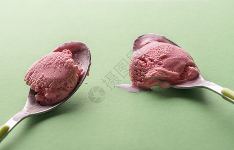 两勺草莓冰淇淋绿色背景水果冰淇淋和汤匙一起吃美味的夏天清新甜点图片