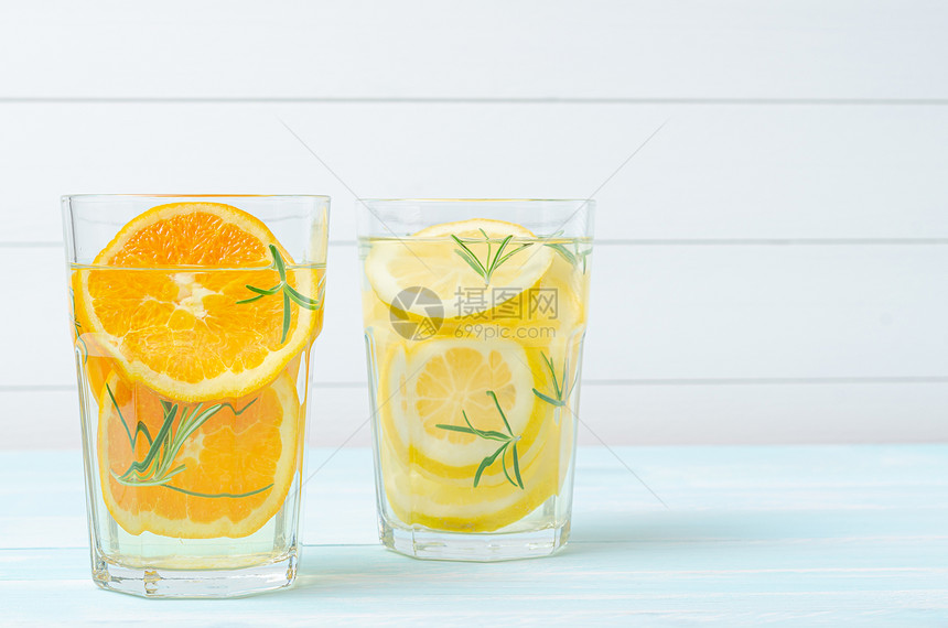 准备柠檬汁饮料和橙柠檬在罐子里加柠檬在户外桌子上加迷迭香图片