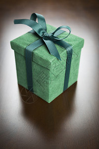绿色礼物盒带丝和弓子放在木质表面图片