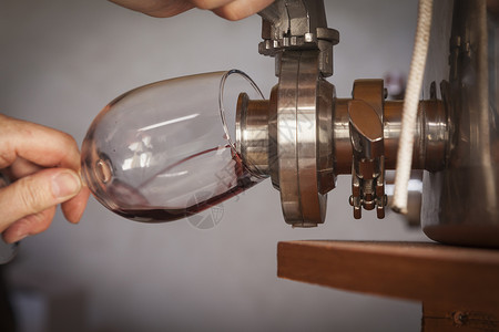 葡萄酒将的味道从桶里倒到玻璃图片