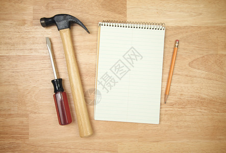 纸铅笔锤子和螺丝刀在木质背景上图片