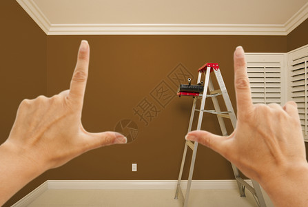 用梯子油漆桶和滚筒将棕色漆房壁布在室内图片