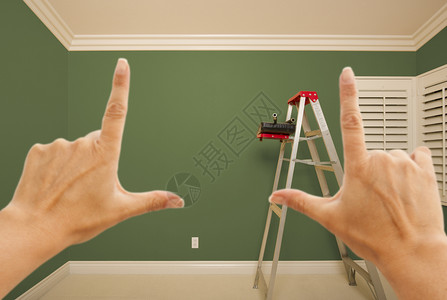 用梯子油漆桶和滚筒在室内铺上绿色的油漆房墙壁图片
