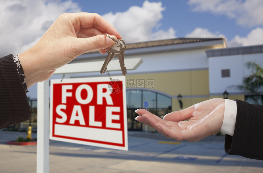 房地产经纪人在空置商业办公室前交出钥匙供售图片