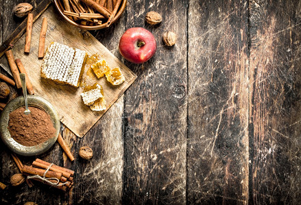 新鲜蜂蜜苹果和肉桂木制背景图片