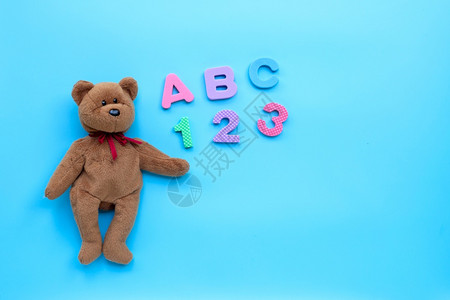 使用英语字母和蓝色背景数字的熊褐色玩具教育概念复制空间图片