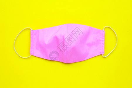 黄色背景上手工制作的粉红布面罩图片