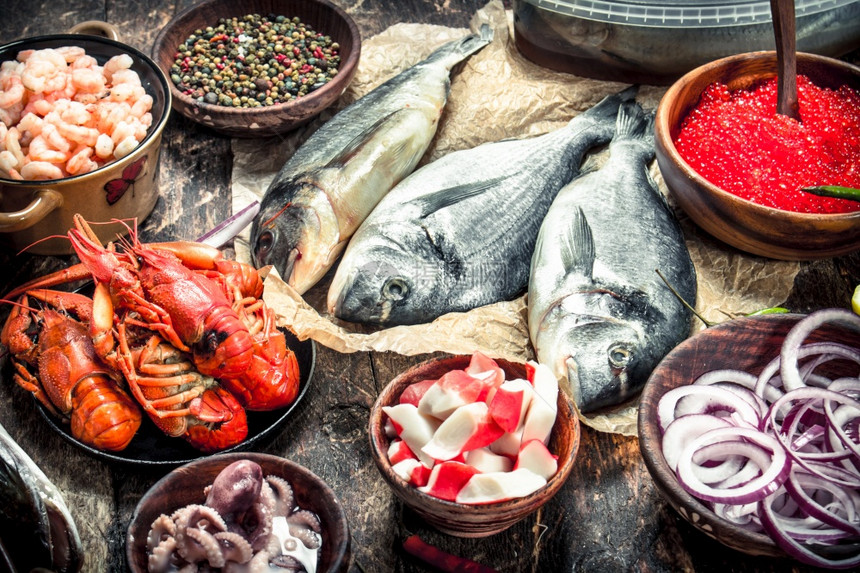 不同的海产食品有虾和红鱼子酱有木制背景不同的海产食品有虾和红鱼子酱图片
